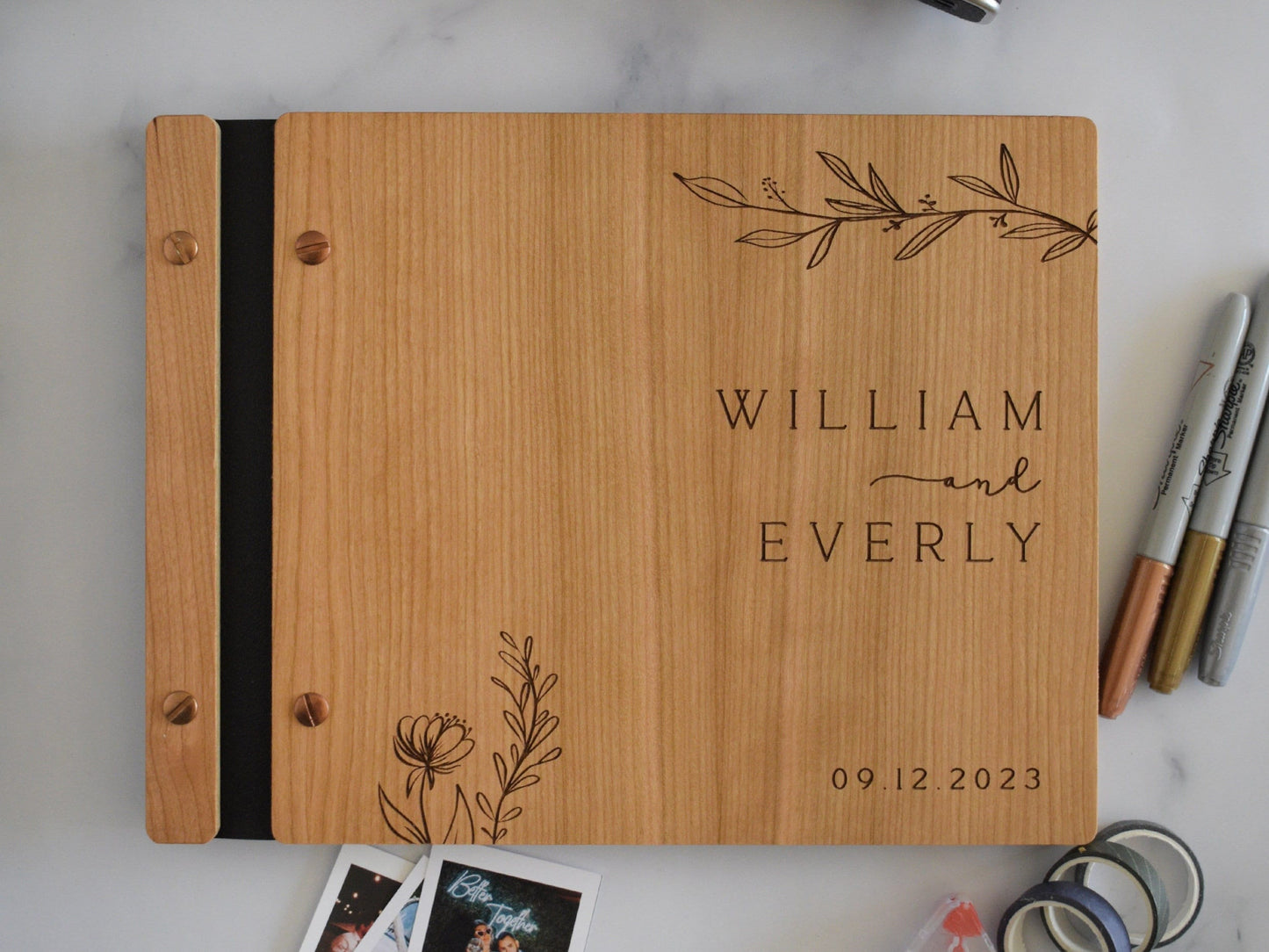 Minimalist bamboo wedding guest book in an cherry wood finish with engraved, customized couples names and a boho leaf design on the cover.