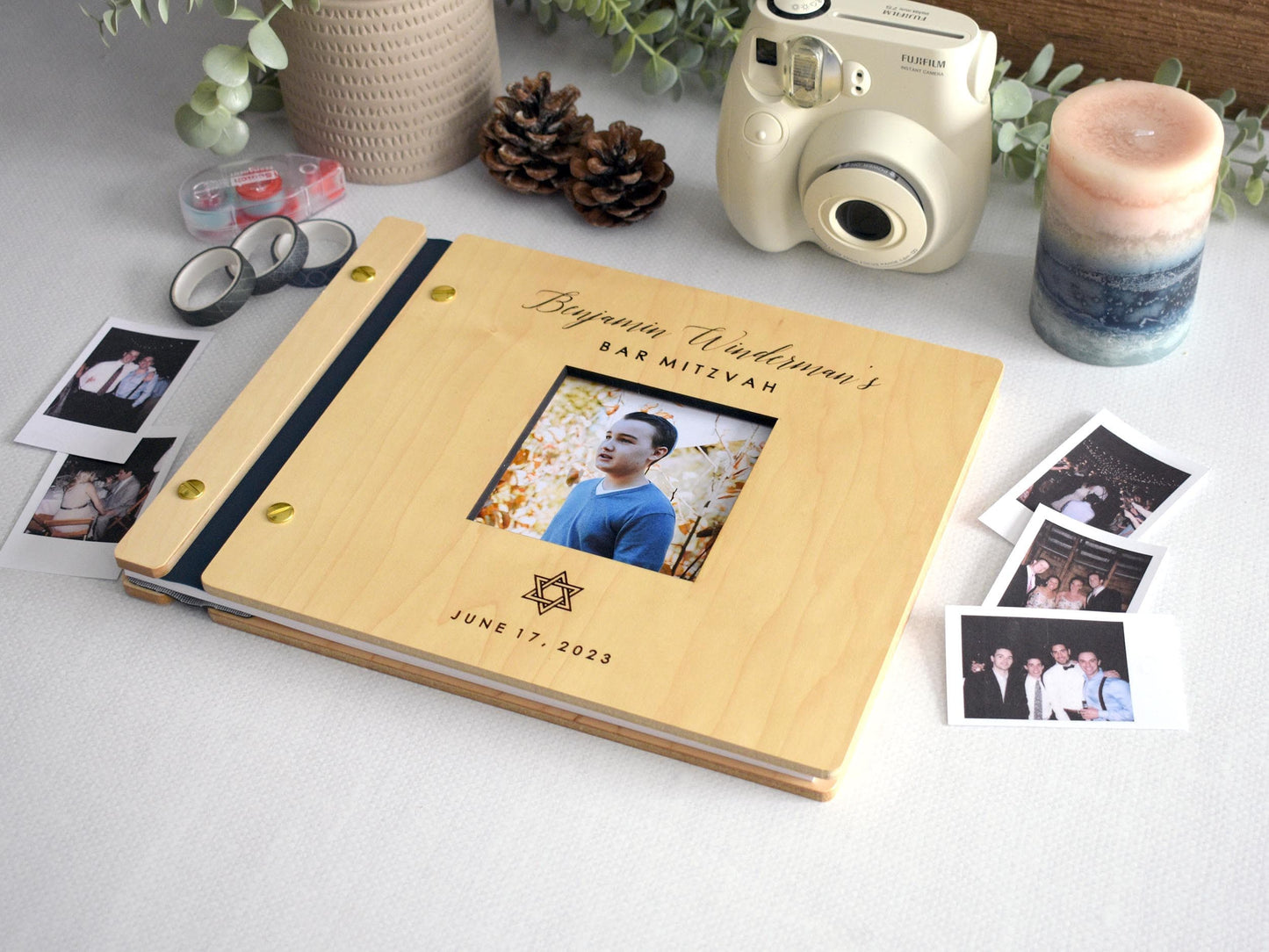 Custom Bar Mitzvah guest book featuring a photo title page and personalized details. The book is decorated with a Star of David and surrounded by Polaroid pictures, making it a perfect keepsake for capturing special memories.